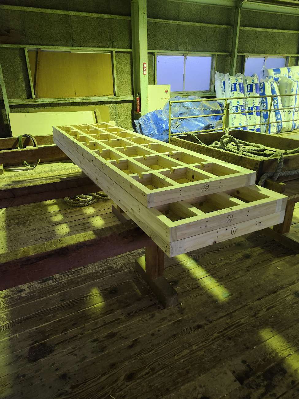 プレカット工場で土台材を確認している様子